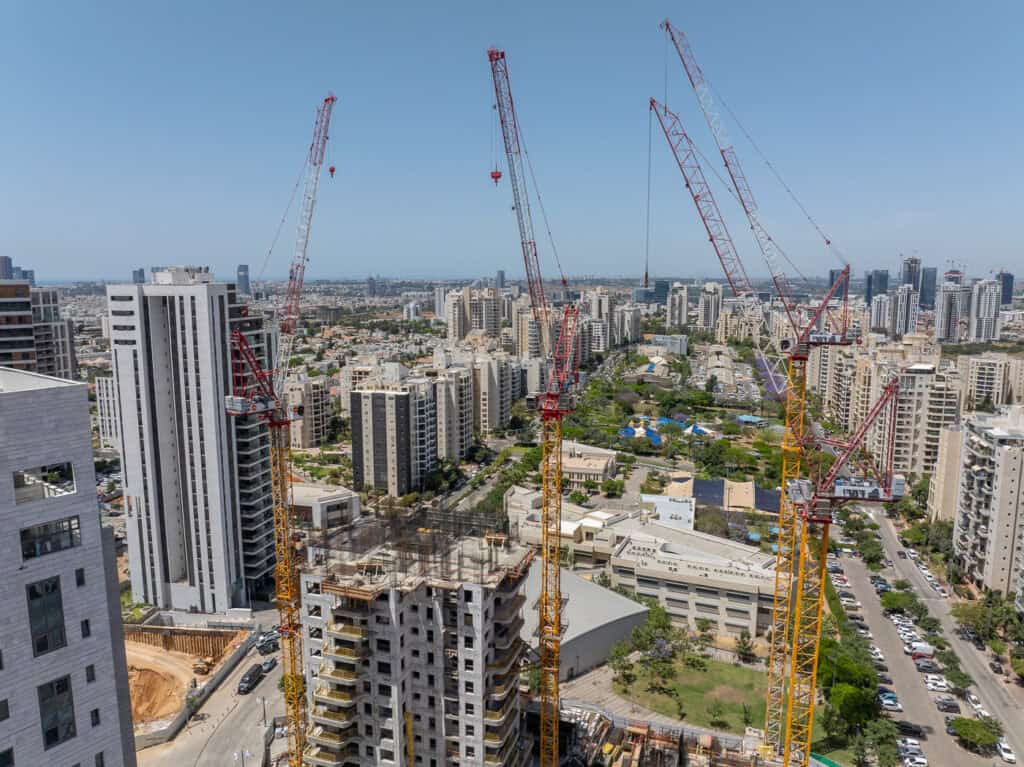 עגורני מנוף בגבעת שמואל עם נוף עירוני מרהיב.